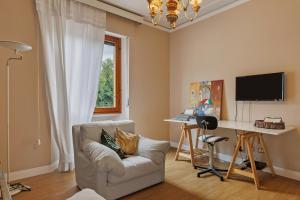 a living room with a chair and a desk with a computer at Il nido Emozioni charme e colori in Fiesole