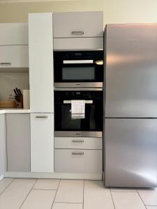 a stainless steel refrigerator and stove in a kitchen at FAAKER SEE HIDEAWAY - Apartment mit Garten in Faak am See