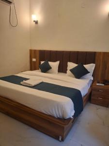 Hanumant Resort في دهرادون: غرفة نوم بسرير كبير مع لوح رأس خشبي