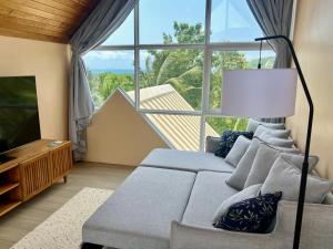 ein Wohnzimmer mit Couch und großem Fenster in der Unterkunft Luxury Retreat, Pool, Gym, Sauna, Spacious land & Garden in Ko Phangan