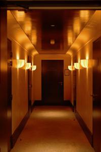 an empty hallway with a black door and lights at Hôtel Littéraire Stendhal et Spa in Nancy