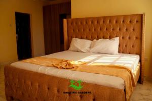 a bed in a hotel room with a large headboard at Kristina Gardens in Voi