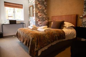 a bedroom with a bed with a blanket and towels on it at The Greenman Fownhope Hereford in Fownhope