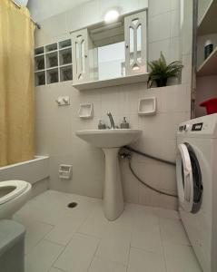 a bathroom with a sink and a washing machine at Ναϊάδες in Konístrai