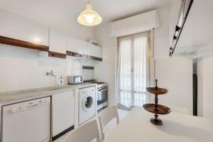 a kitchen with a washing machine and a table and chairs at Lerici sea view private parking best position in Lerici