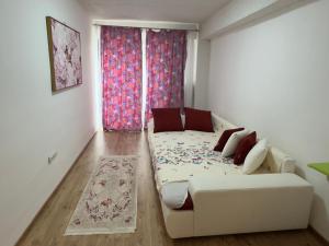 a living room with a couch and a window at Apartament RYO in Şelimbăr