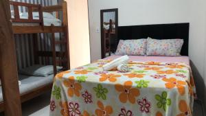 1 dormitorio con 2 literas y colcha con flores en Valley House - Hostel, en Piranhas