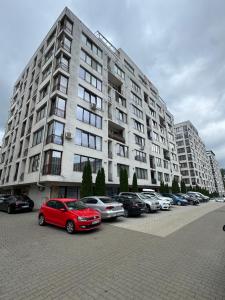 a large building with cars parked in a parking lot at Apartament RYO in Şelimbăr