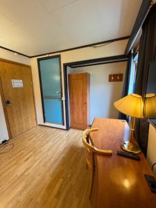 a room with a desk with a lamp and a door at Camp Skytterhuset in Hammerfest