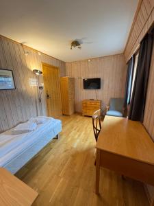 a room with a bed and a table and a tv at Camp Skytterhuset in Hammerfest +17 photos