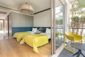 two beds in a room with a table and chairs at Voyage Belek Golf & Spa Hotel in Belek