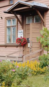 a wooden house with a flower box on the door at Huoneistohotelli Marja in Mikkeli