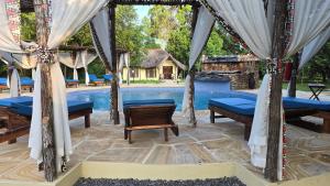 a pavilion with tables and chairs next to a pool at Africa Safari Selous Nyerere national park in Nyakisiku