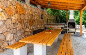 リスィカにあるVilla Risika 1 with pool island Krk by Villas Guidの石壁前の木製ピクニックテーブル