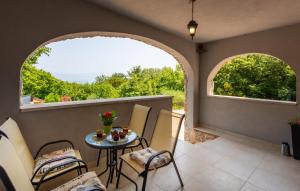 リスィカにあるVilla Risika 1 with pool island Krk by Villas Guidのバルコニー(テーブル、椅子付)、窓2つが備わります。