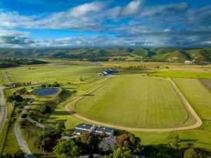 an aerial view of a field with mountains in the background at Rhone Hill Polo Club in Plettenberg Bay