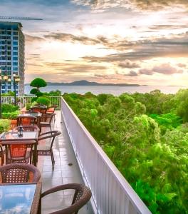 un balcón de un hotel con mesas y sillas en New Nordic VIP 6, en Pattaya South 12 fotos más
