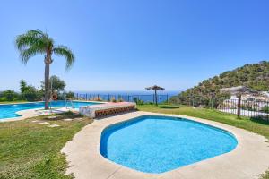 a swimming pool with the ocean in the background at Stunning sea views pool garden in La Herradura