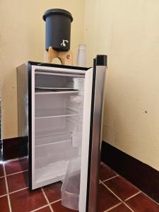 Un refrigerador abierto con un recipiente encima. en One Day Trip Hostel, en Antigua Guatemala