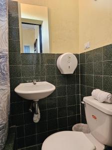 a bathroom with a toilet and a sink at One Day Trip Hostel in Antigua Guatemala +38 photos