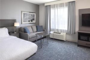 a hotel room with a bed and a couch at Hampton Inn & Suites Portsmouth Downtown in Portsmouth +35 photos