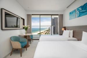 a hotel room with two beds and a view of the beach at Radisson Hotel Danang in Danang