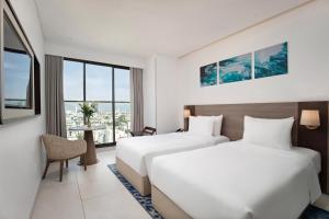 two beds in a hotel room with a view at Radisson Hotel Danang in Danang