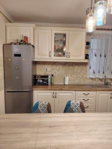 a kitchen with white cabinets and a stainless steel refrigerator at Apartament Confort Dambul Pietros Targu-Mures in Târgu-Mureş
