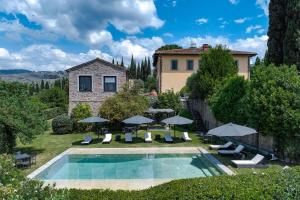an external view of a house with a swimming pool with umbrellas at Villa Leonardo - Vinci in Vinci