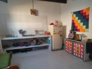 a kitchen with a refrigerator and a table with a guitar at Iguaque Lodge - Apto Ideal grupos - Familias in Villa de Leyva +4 photos