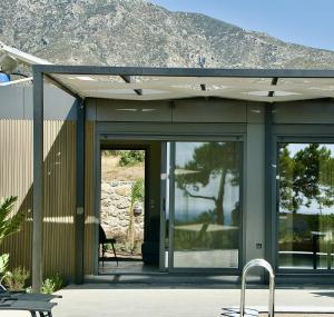 a house with glass doors with a mountain in the background at LIViT Condo Elafonisi in Agios Padeleimon