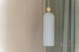 Un jarrón blanco colgado en una pared junto a una cortina. en Your Holidays Aquamarina Prima 60, en Międzyzdroje