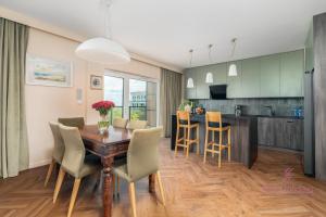 Una cocina y un comedor con mesa y sillas de madera. en Your Holidays Aquamarina Prima 60, en Międzyzdroje