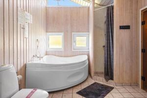 a bathroom with a white tub and a shower at 233-Thisted-Tunvej-5 in Thisted