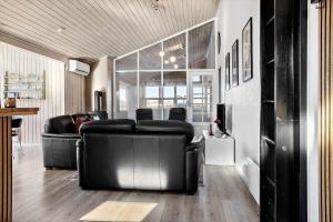 a living room with black leather furniture and a table at 941-Thisted-Klitstien-37 in Torsted