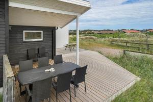 a wooden deck with a table and chairs on it at 941-Thisted-Klitstien-37 in Torsted