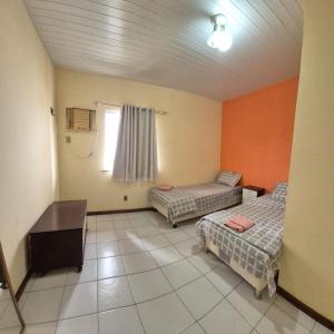 a room with two beds and a desk and a window at Hospede-se bem em Salinas in Salinópolis +12 photos