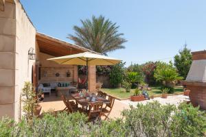 a patio with a table and an umbrella at Finca Kelly in Artá