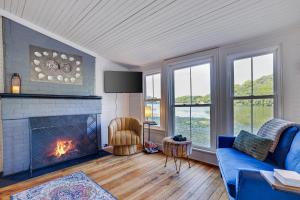 ein Wohnzimmer mit einem Kamin und einem blauen Sofa in der Unterkunft Heart's Desire, a Cottage With Stunning Lake Views in Effort