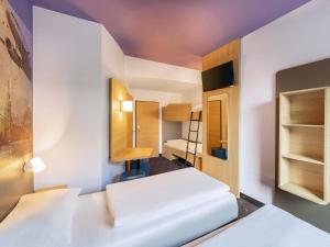 a room with two beds and a bunk bed at B&B Hotel Düsseldorf-Airport in Düsseldorf
