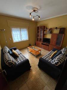 a living room with two couches and a coffee table at Casa La Peña in Luarca