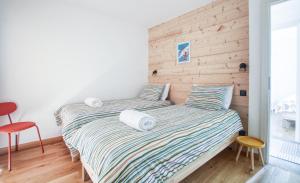 2 letti in una camera da letto con parete in legno di Aiguille Verte Apartment a Les Houches Altre 10 foto