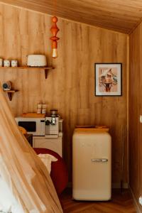 a small kitchen with a refrigerator in a room at Nowoczesne Domki na Drzewie - Kołobrzeg - Sauna - PolanaGlamp in Nieżyn