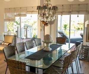 une salle à manger avec une table et des chaises en verre dans l'établissement Cómoda casa vista espectacular zona Manantiales, à Balneario Buenos Aires