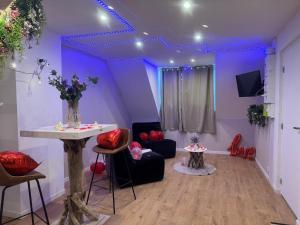 a living room with purple walls and a table and chairs at L'ouragan in Wimille