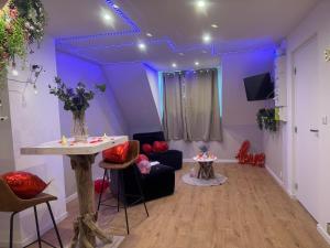 a living room with purple lighting and a table and chairs at L'ouragan in Wimille +3 photos