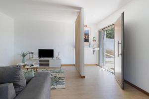 a living room with a couch and a television at Al Do Paço - Between Braga e Geres in Amares