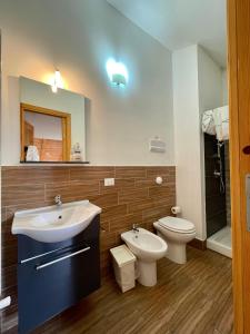 a bathroom with a sink and a toilet and a mirror at Flyhouse PARCHEGGIO AUTO BICI GRATUITO in Piana degli Albanesi +9 photos