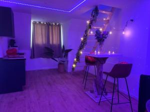 a room with a purple room with a table and lights at L'ouragan in Wimille