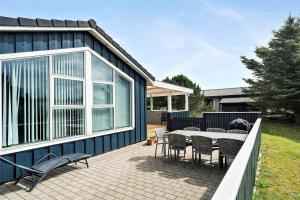 a blue house with a patio with a table and chairs at 618-Thisted-Fiskervej-82 in Thisted